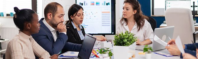 A small business owner leads a discussion with their team in a meeting.