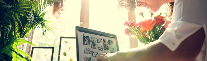 Female flower shop owner working on laptop promoting business on social media