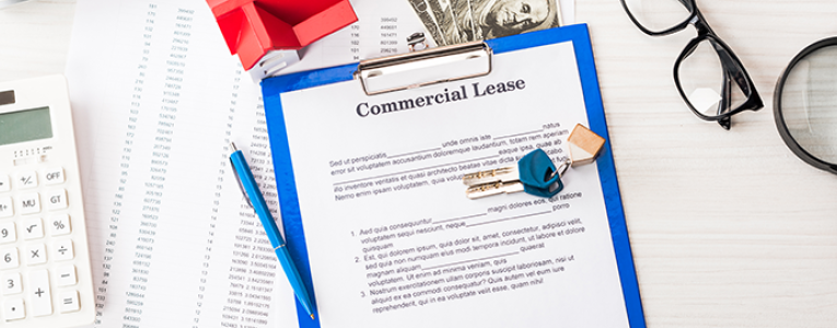  Save Download Preview top view of document with commercial lease lettering on clipboard near keys, house model, pen, calculator, magnifier, money and glasses