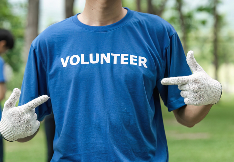Close up young man volunteering wearing t-shirt with volunteer message